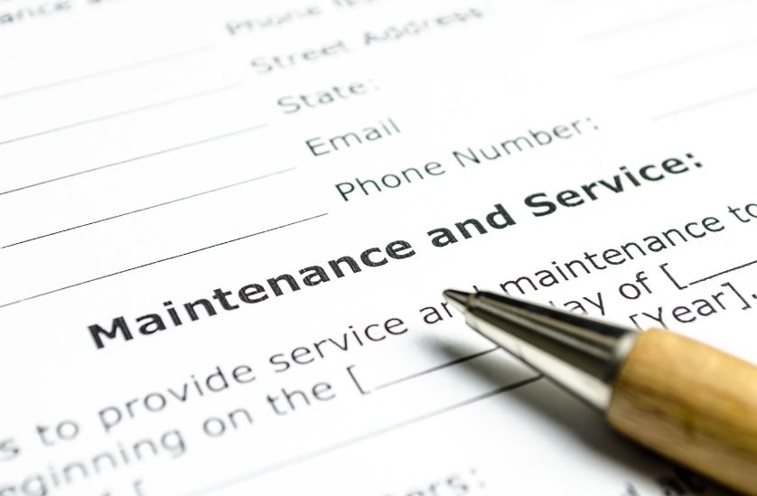 Close-up of a maintenance and service form with a pen, highlighting the importance of service agreements and customer information collection.
